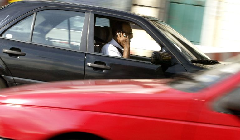 gettyimages-1358158-1790696916 LONDON - AUGUST 21: A man talks on his mobile telephone while driving his van August 21, 2002 in London, England. The Department of Transport has confirmed it is considering a complete ban of the use of mobile phones by drivers, even when stopped at lights or in a traffic jam. The law currently prosecutes motorists using mobiles only if they fail to keep proper control of their vehicle. (Photo by Scott Barbour/Getty Images)