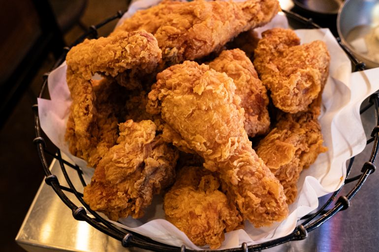 gettyimages-2248257979-1791567481 Golden fried chicken pieces stacked in a basket, offering a timeless savory fast food or comforting dining choice