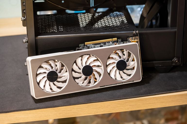 Krakow, Poland - March 2023: Gigabyte GeForce RTX 3060 Ti GPU, graphics card laying next to a new PC case, upgrading, installing, buying a new graphic processing unit, 3 fans high end product shot