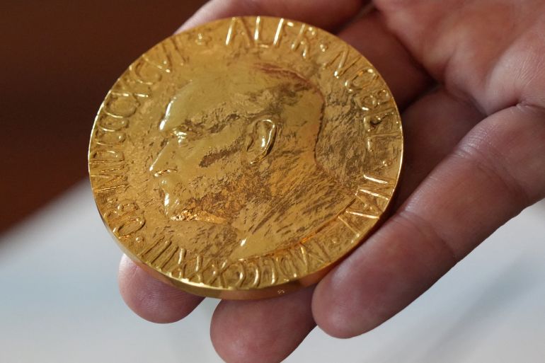 reuters_68e77573-1759999347 FILE PHOTO: An employee of the Norwegian Nobel Institute holds a replica of a Nobel Peace Medal in the Institute in Oslo, Norway, September 9, 2025. REUTERS/Tom Little/File Photo