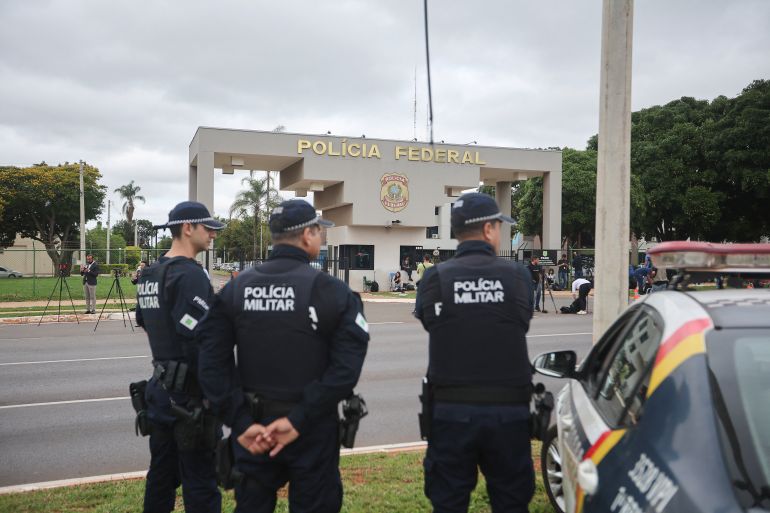 reuters_6921eff7-1763831799 Military police stand outside the Brazilian Federal Police Regional Headquarters, where Brazil's former President Jair Bolsonaro was taken after being placed in federal police custody as a preventative measure related to his house arrest, in Brasilia, Brazil, November 22, 2025. REUTERS/Mateus Bonomi