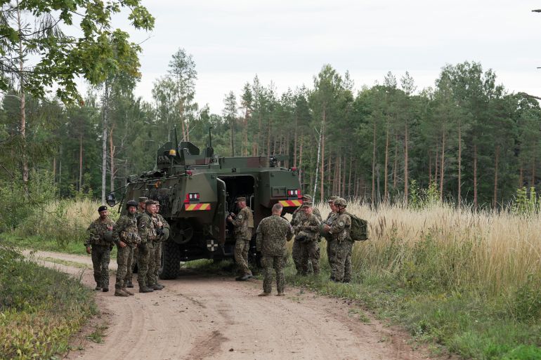 reuters_6a7f40e8-1786724584 Servicemen of the Latvian National Guard gather before a search operation for the debris from an intercepted drone, amid Russia's attack on Ukraine, in Rugaji, Latvia, August 14, 2026. REUTERS/Janis Laizans