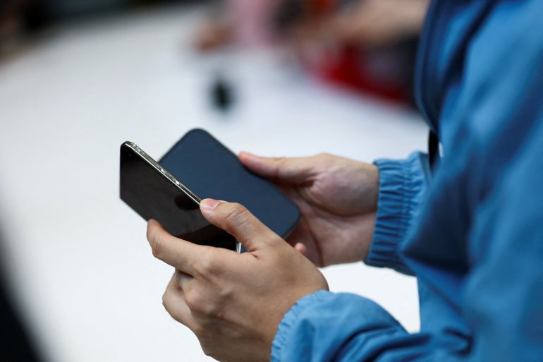reuters_6ac773c3-1791456195 A person holds the new foldable iPhone Duo during Apple's event at the Steve Jobs Theater in Cupertino, California, U.S. September 9, 2026. REUTERS/Carlos Barria