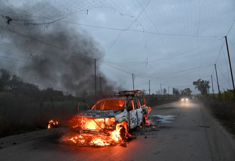 SENSITIVE MATERIAL. THIS IMAGE MAY OFFEND OR DISTURB A body burns near a burning car, hit by a Russian FPV drone, amid Russia's attack on Ukraine, in Donetsk region, Ukraine October 14, 2026. REUTERS/Stringer