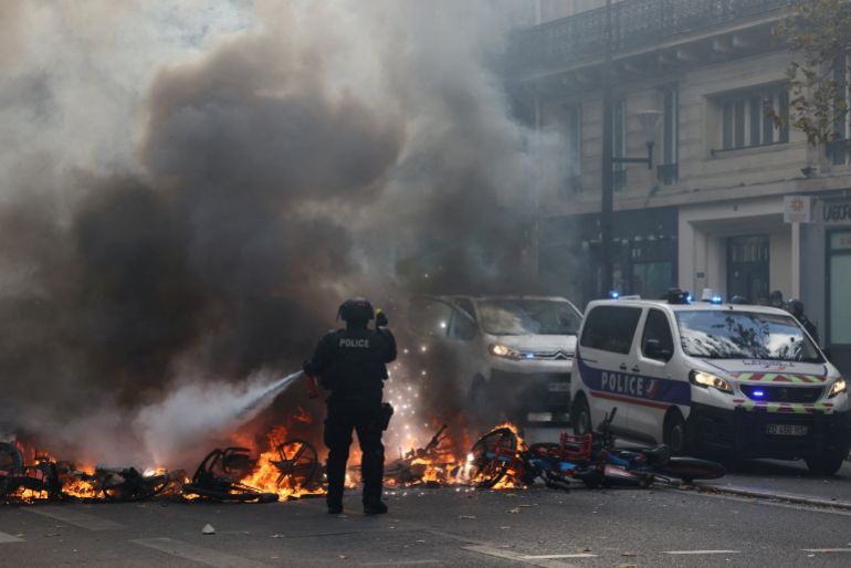 reuters_6ad7a760-1792517984 FILE PHOTO: A French police officer extinguish burning bicycles during a demonstration against the cost of living and rising fuel prices in Paris as part of nationwide protests called by the "Yellow Vests" movement, joined by French high school and university students, teachers and parents demanding better school conditions and government action, as well as labour unions, workers, farmers and retirees, France, October 17, 2026. REUTERS/Jack Taylor/File Photo