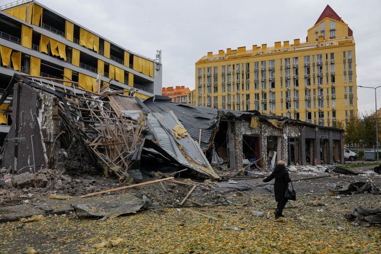 A woman walks past a crater in a residential area that appeared after a late evening Russian missile strike, amid Russia's attack on Ukraine in Kyiv, Ukraine October 30, 2026. REUTERS/Valentyn Ogirenko