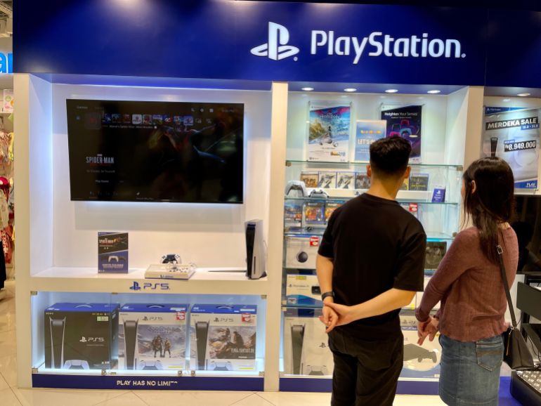 Jakarta, Indonesia - August 1st 2023 : husband and wife are looking at Playstation 5 at Kidz Station which is in Pondok Indah Mall 3.