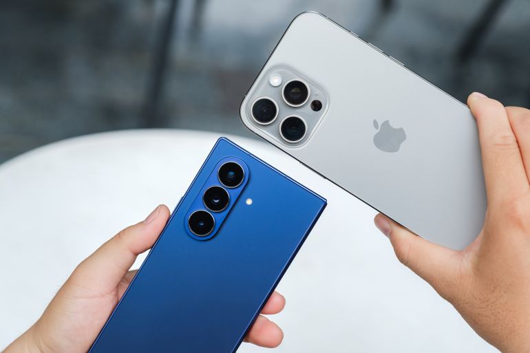 shutterstock_2662328637-1774957835 HO CHI MINH CITY, VIETNAM – AUGUST 5 2025: Samsung Galaxy Z Fold7 and Apple iPhone 16 Pro Max shown side by side, highlighting foldable inner display and periscope zoom camera module