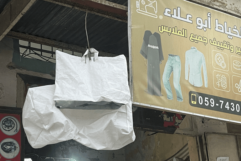 swrt-1-1791327736 صورة 1 حقائب الشوادر معروضة للبيع على واجهة محل الخياط معين شحبير حقائب من شظايا الخيام.. حين يغزل خياطو غزة الأمل من الشوادر المهترئة